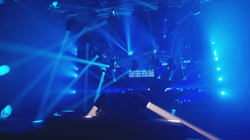 Arolla Aqua M-LT beams fanning across a blue-lit concert stage